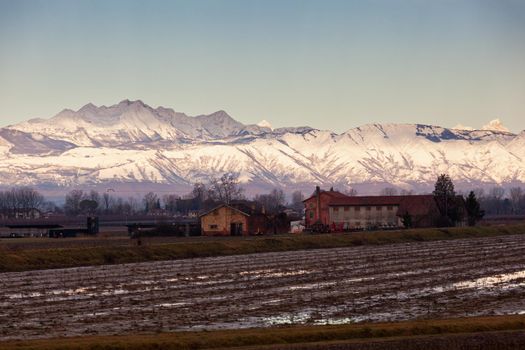 View of the Italian countryside with alp mountains on the background in the winter season