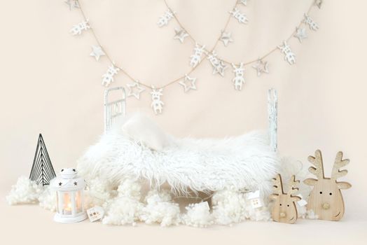 Newborn baby studio furniture bed for Christmas infant child photoshoot with white festive Xmas decoration. Tiny designed spot for kid New Year holiday studio portrait