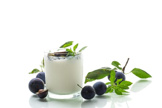 sweet homemade yogurt with fresh plum slices in a glass isolated on white background
