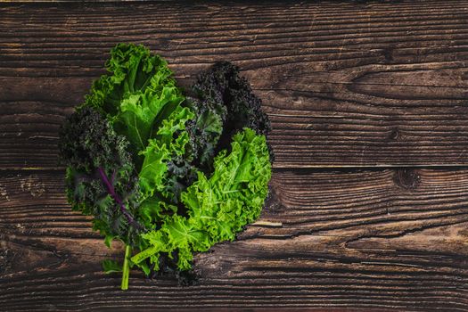 green leafy kale vegetable isolated on wooden table background