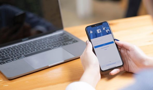 CHIANG MAI ,THAILAND - AUG 18, 2022 : Woman hand holding iPhone X to use facebook with new login screen.Facebook is a largest social network and most popular social networking site in the world..