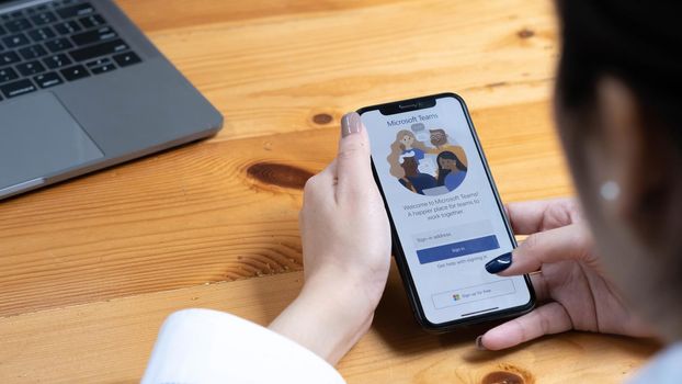 CHIANG MAI, THAILAND - APR 11, 2022 : A working from home employee is downloading the Microsoft Teams social platform, ready for remote working in isolation from home.