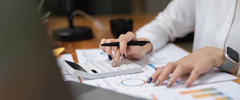 Woman accountant using calculator and computer in office panoramic banner, finance and accounting concept.