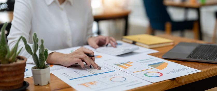 Woman accountant working with computer and calculator for business and financial expense.