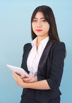 Young women standing in suit holding her digital tablet computor against blue background