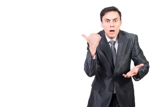Excited man in formal suit pointing aside with astonishment and expressing surprise standing against white background