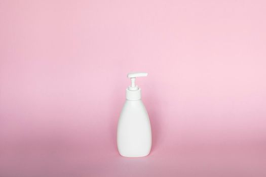 White plastic bottle with white dispenser, isolated on pink background