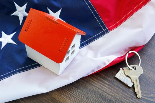 USA flag, a house model and keys. VA loan concept.