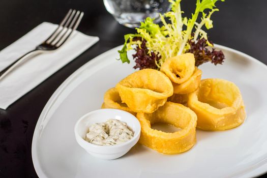 Fried squids or octopus. Fried calamari with tartar sauce.