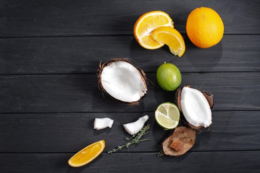 Set of fruits tropical lime, coconut on, orange, the background of an old dark wooden table, top view, flat.