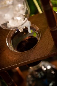 cold drip coffee tower with soft-focus and over light in the background