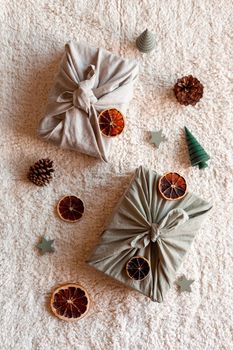 Christmas gifts textile packed, decorated with natural materials, top view, zero waste concept