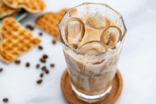 Iced caramel latte coffee in a tall glass with caramel syrup