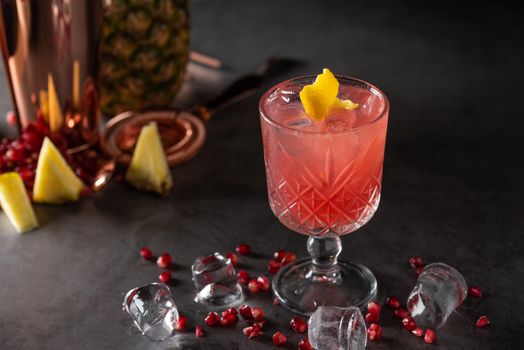 refreshing and light pomegranate and pineapple summer cocktail with ice cubes