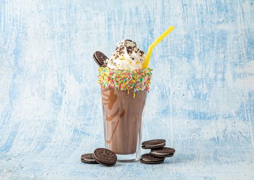 Cream and chocolate milkshake on blue background