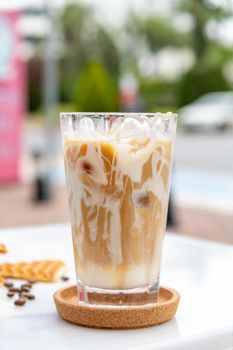 Iced caramel latte coffee in a tall glass with caramel syrup