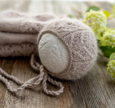 tender knitted for newborn on wooden background