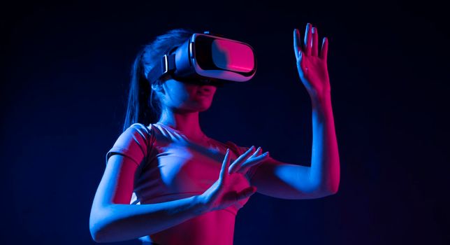 Brunette woman Architect worker wearing VR headset for working design of new architectural project in dark studio. Technology futuristic virtual reality design