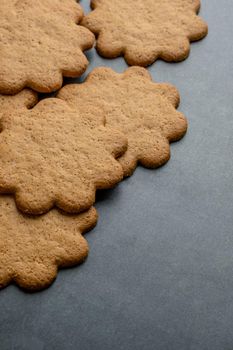 Fresh ginger biscuits piled on dark stone background