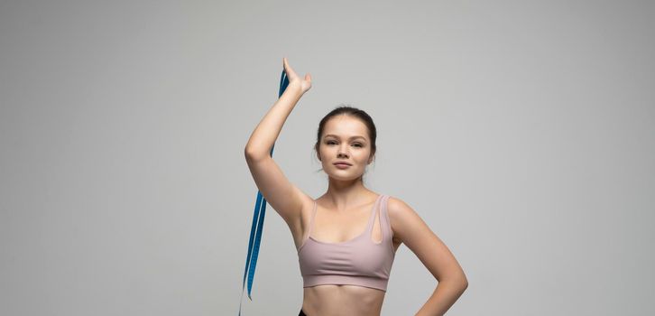 Brunette woman with a measurement tape. Athletic slim woman measuring her body by measure tape after a diet. Concept of healthy eating and dieting