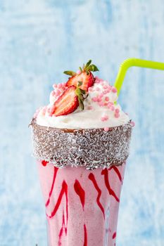 Refreshing strawberry milkshake on blue stone background