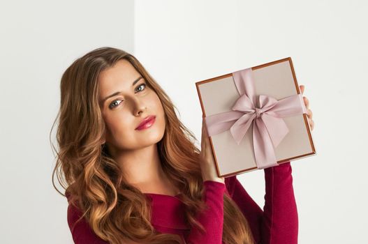 Holiday present for birthday, baby shower, wedding or luxury beauty box subscription delivery, happy woman holding a wrapped pink gift on white background