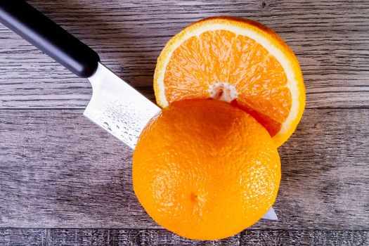 Slicing oranges top view. There is a knife and pieces of orange on the table. Sliced orange halves. Juice freshly squeezed.