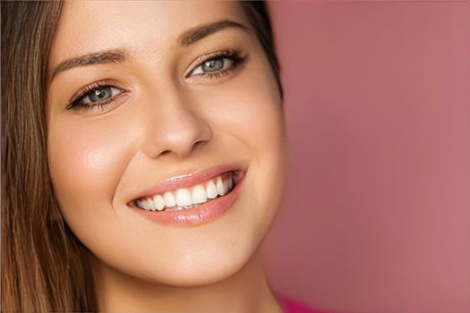 Beauty, makeup and skincare cosmetics model face portrait on pink background, smiling woman with natural makeup, perfect healthy teeth, dental care closeup