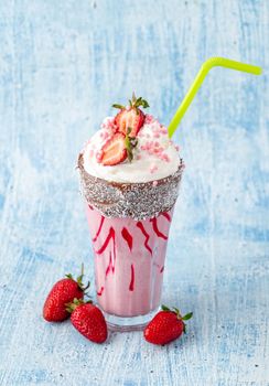 Refreshing strawberry milkshake on blue stone background