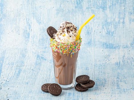 Cream and chocolate milkshake on blue background