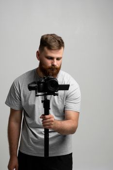 Professional video operator with a dslr camera on 3-axis gimbal stabilizer. Filmmaking, videography, hobby and creativity concept