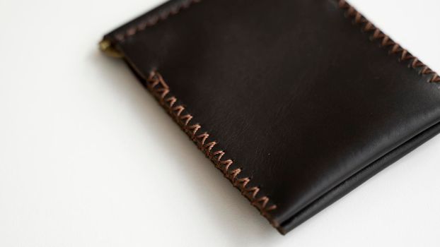 Brown money clip handmade from genuine leather on white surface