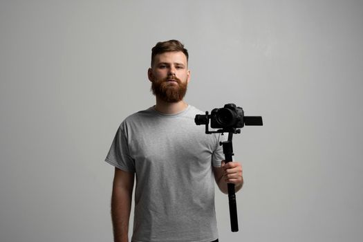 Professional video content creator with a dslr camera on 3-axis gimbal stabilizer. Filmmaking, videography, hobby and creativity concept