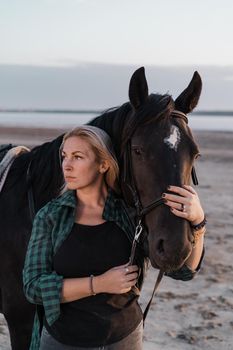 Portrait of adult woman with beautiful horse in nature. Sunlight, silhouette.Concept of love for lesser brothers, caring and animal training.