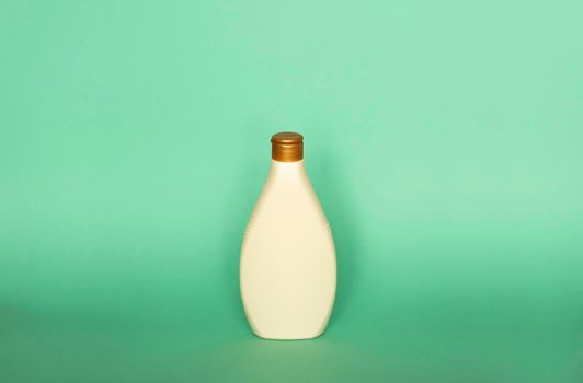 Beige blank plastic bottles isolated on green background