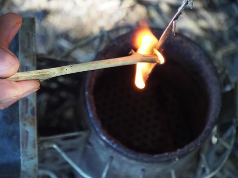 starting a bee smoker before harvesting honey hives in the farm.