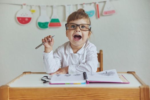 Charming child plays pretending to be a teacher.