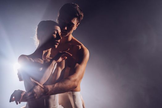 Pair touching each other with hands and passion. Love concept. Professional, sensual ballet dancers performed by sexual couple in white wear