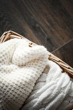 Knitwear, fabric textures and rustic lifestyle concept - Knitted winter clothes in a basket