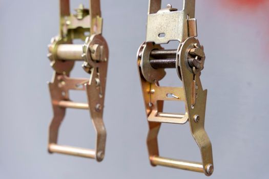 Close-up of ratchet cargo ties. metal buckles on belts straps with ratchets for fixing cargo in the back on a gray background