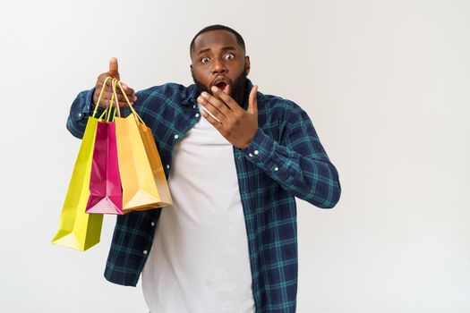 Happy african american man holding shopping bags on white background. Holidays concept.