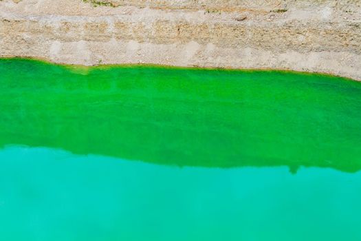 Lake formation in an old abandoned quarry. Quarry lake. Crushed stone dumps in a closed area for stone extraction. Termination of mining operations.