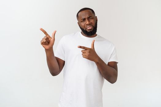 Young amazed African American pointing his finger at white background with copy space for your advertisement.