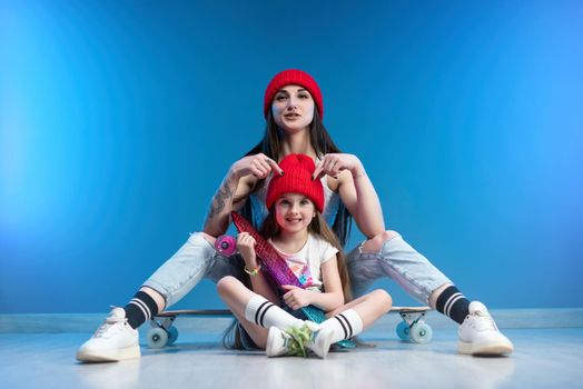 young mother with her daughter on a skateboard and a longboard