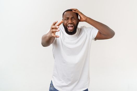 Portrait of shocked young African American man wearing white blank T-shirt looking at the camera in surprise, stunned with some incredible story