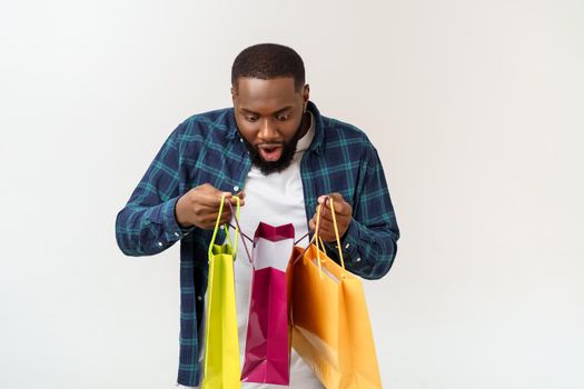 Happy african american man holding shopping bags on white background. Holidays concept.