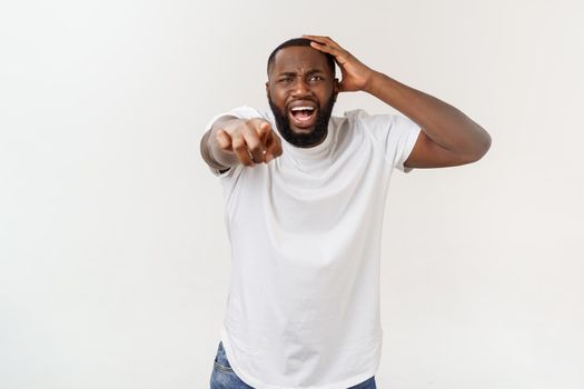 Portrait of shocked young African American man wearing white blank T-shirt looking at the camera in surprise, stunned with some incredible story