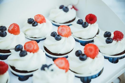 Mini Pavlova meringue with whipped cream and blueberries and strawberries, top view