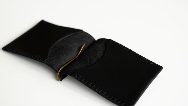 Open black money clip handmade from genuine leather on white surface