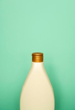 Beige blank plastic bottles isolated on green background